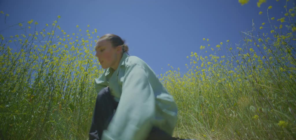 Woman in a field dancing crouched down