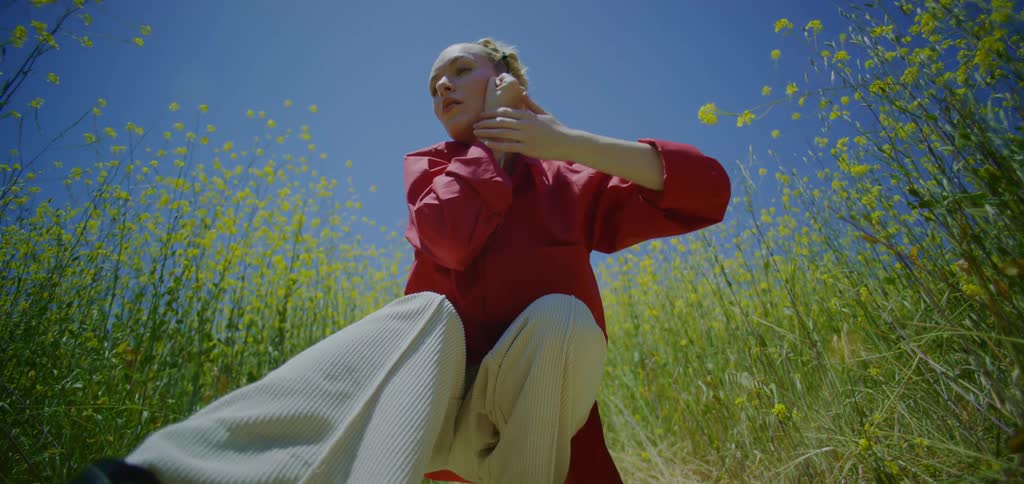 Woman crouching in a field dancing