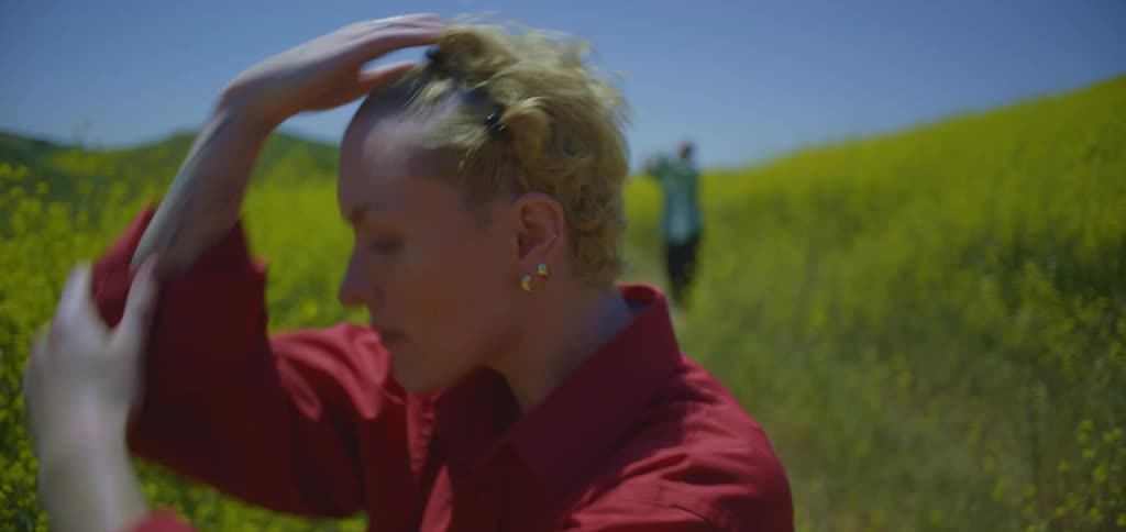 Blonde woman dancing in the foreground and another person dancing in the background