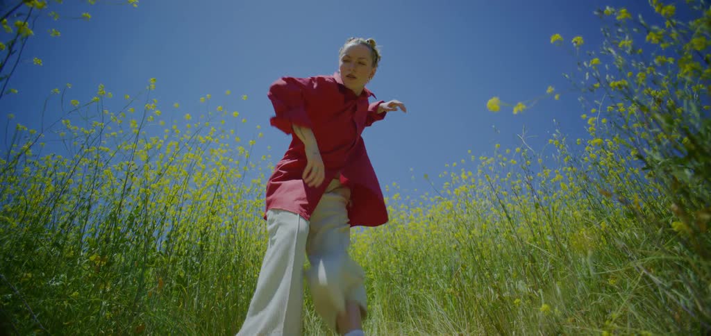 Woman dancing in a field with yellow flowers