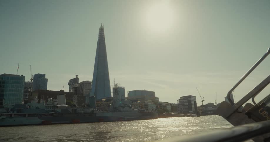 A shot of a sunny day with a triangular shape building towering over the other buildings, the shard