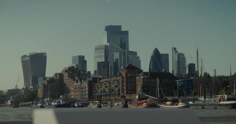 View of londons financial district with skyscrapers and boats docked on the river