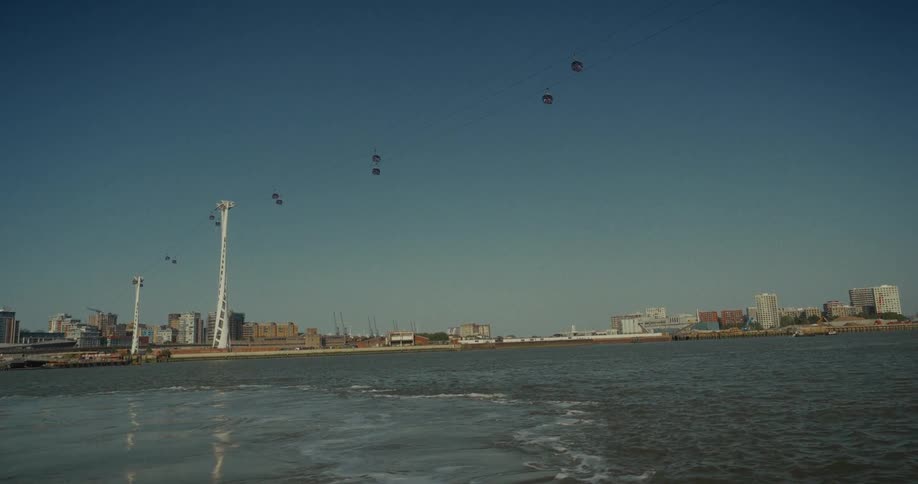 A sky lift is on the shore of the city