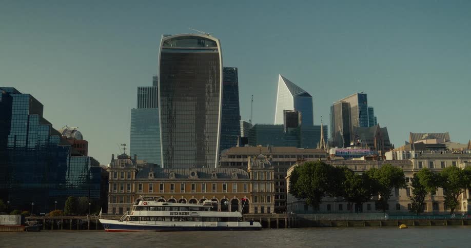 Boat sails on the thames in front of the walkie talkie building and london skyscrapers