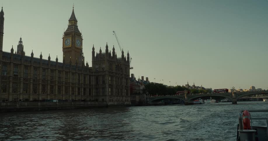 View of the houses of parliament and big ben at sunset with the river thames in the foreground