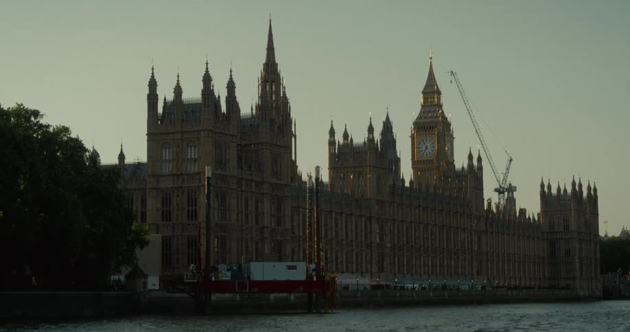Palace of westminster and big ben at dusk seen from the river thames bank