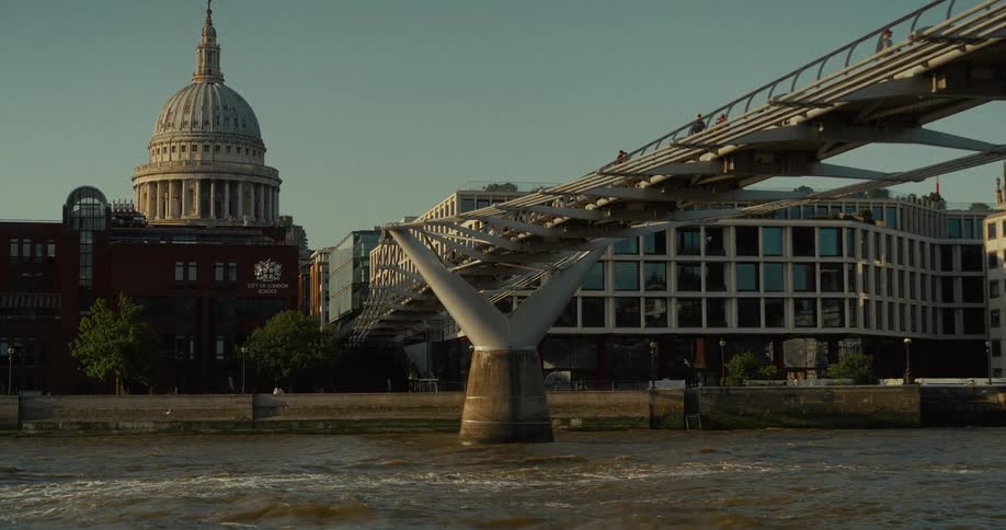 The video shows a view of the millennium bridge in london england the dome of st pauls cathedral is visible in the background