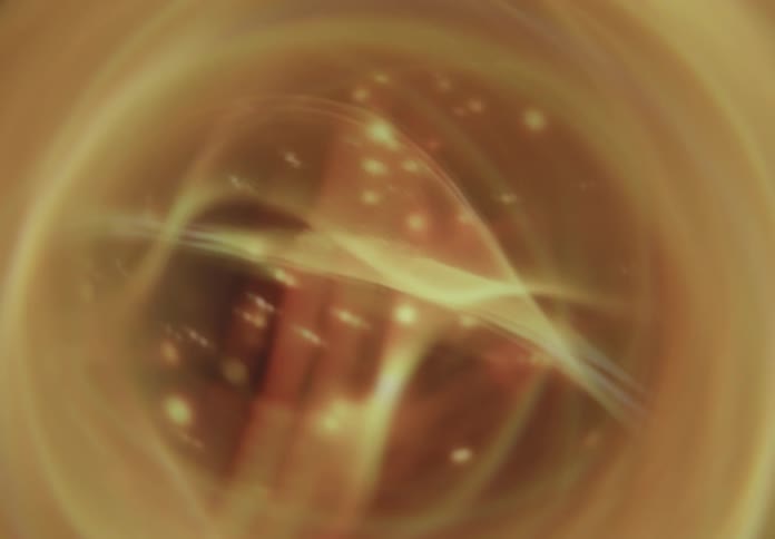 Golden abstract shapes with glowing dots resembling floating particles in space