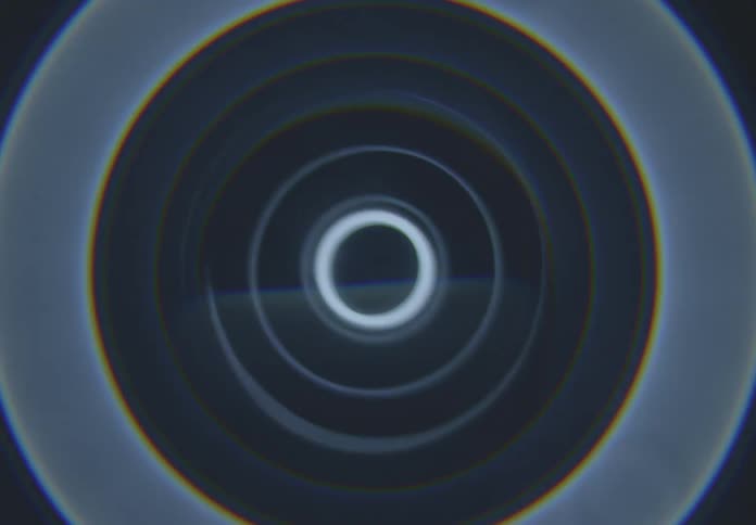 Glowing concentric circles create a hypnotic pattern on a dark background