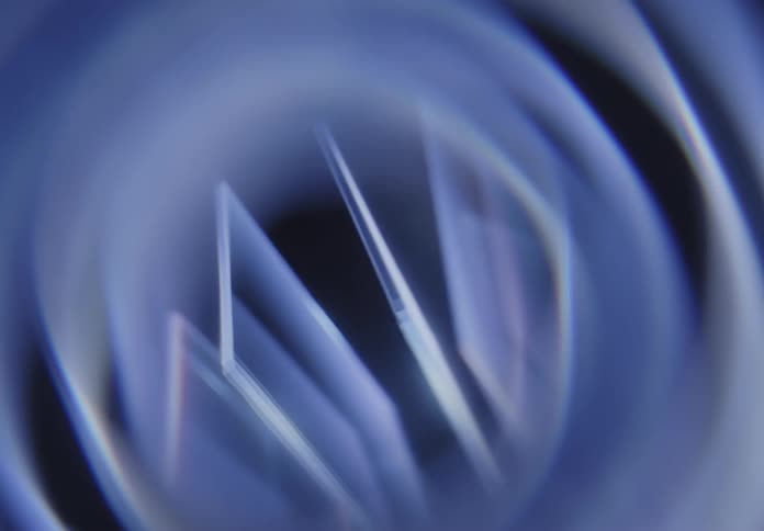 Geometric refractions in bluish tones create an abstract prism effect