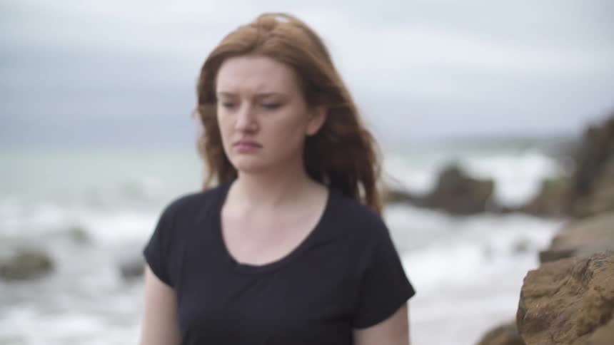 Woman walking on a rocky beach