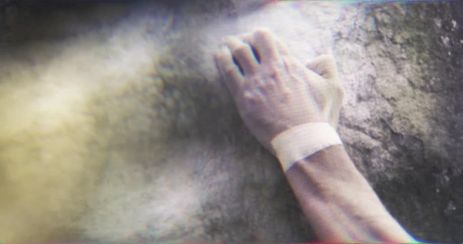 Hand with sports tape grips firmly on rock during climbing