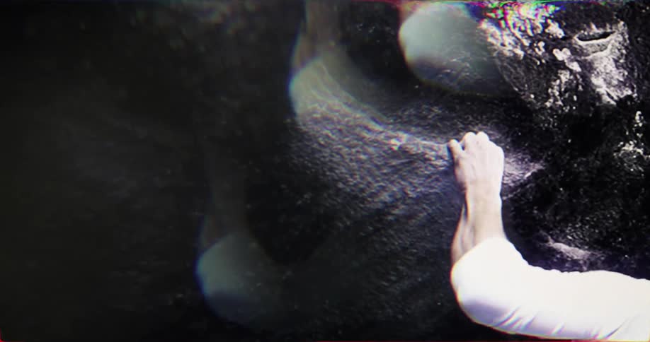 Close up of a young man climbing a rock sideways outdoors during daytime