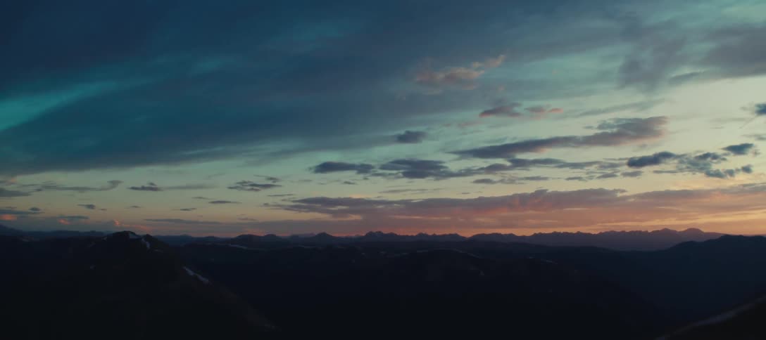 Dark mountain range contrasts with a sky colored by sunset