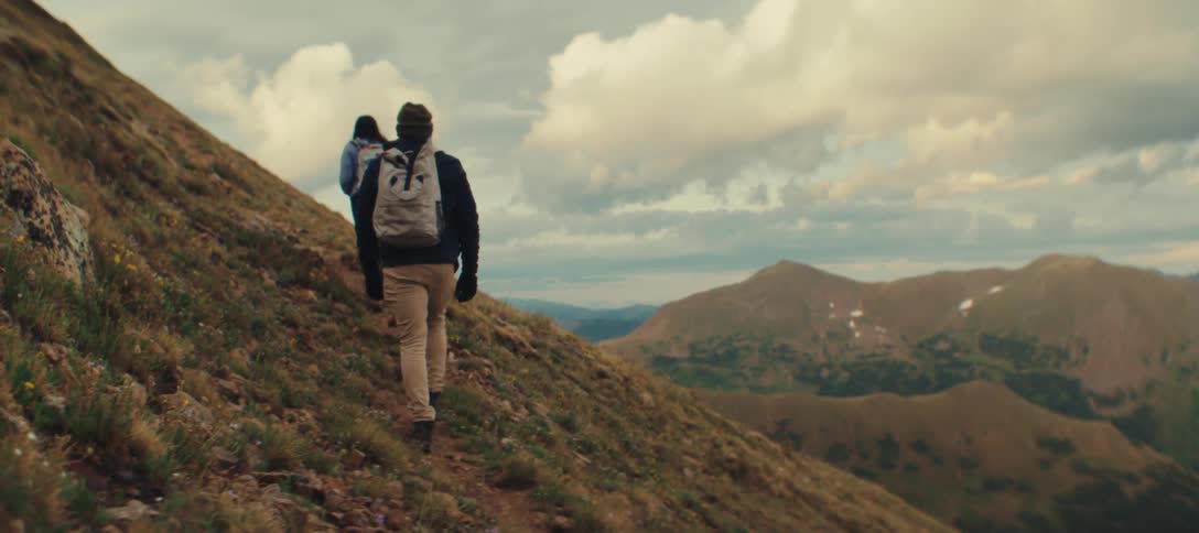 Group of hikers climbs up a mountain slope
