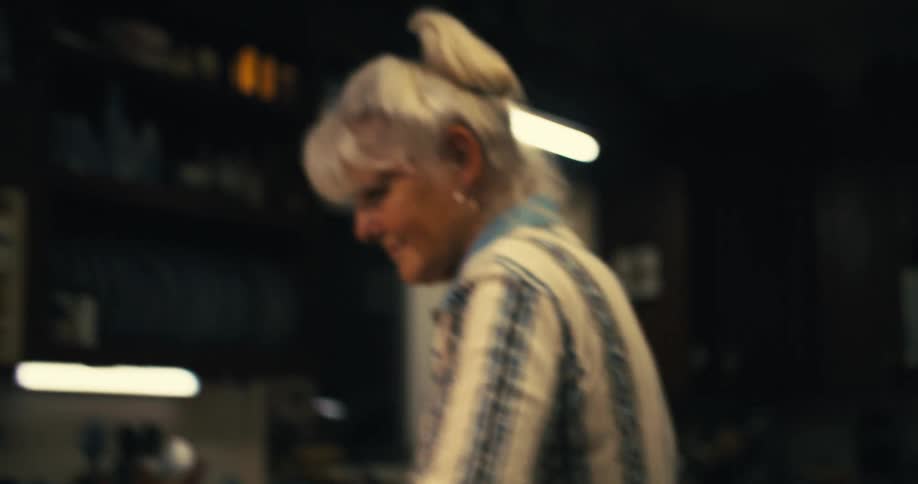 The video shows a person wearing a striped shirt and patterned oven mitts taking a baking dish out of an oven they are holding the dish with both hands and the dish itself contains a goldenbrown casserole or baked food