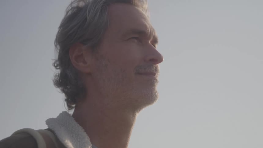 The man is smiling on a sunny day