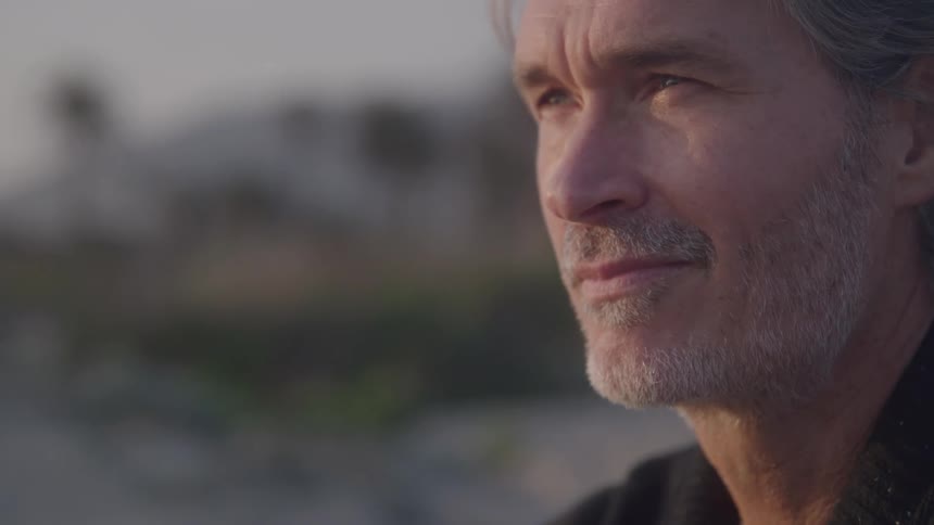 Thoughtful man looks on in warm evening light