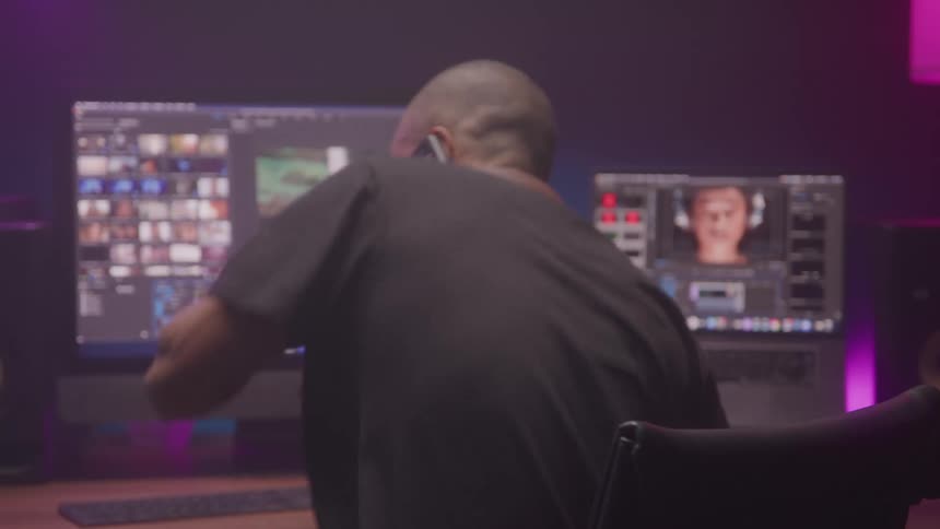 The man talks on his cell phone at the desk