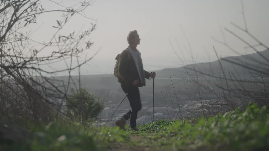 The man is hiking on the foggy mountain