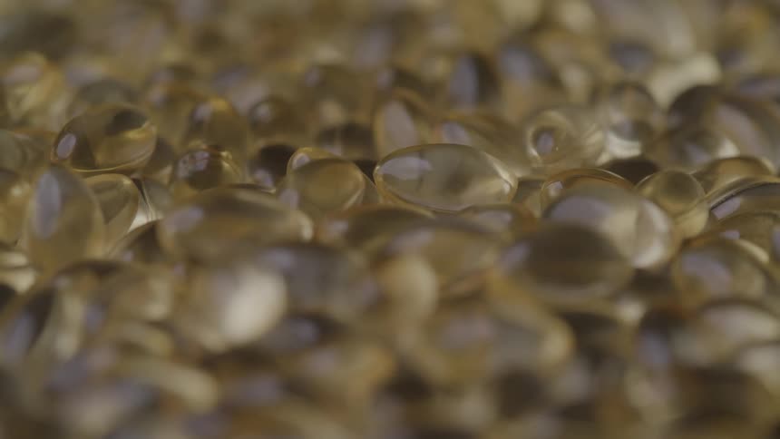 Closeup of golden gel capsules in soft focus
