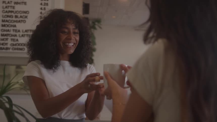 A woman is served coffee in the cafe
