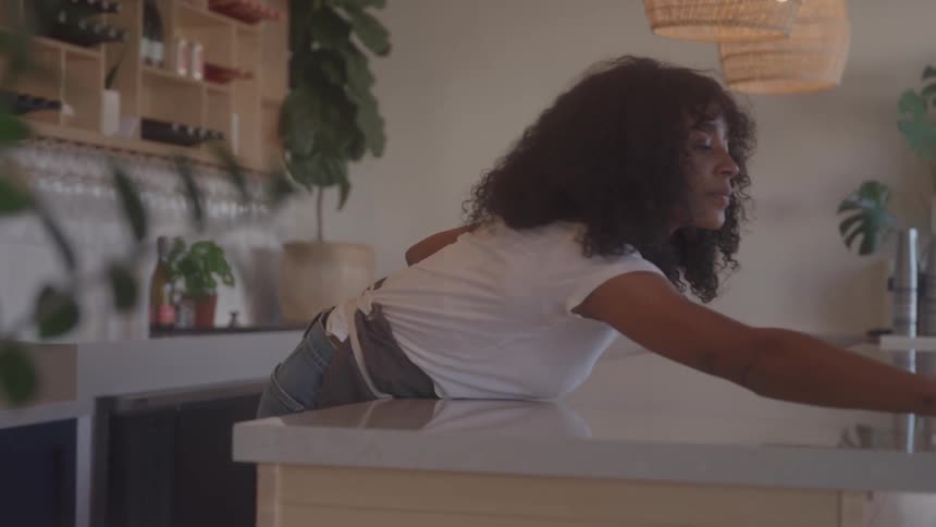A woman wipes down a countertop in a modern cafe
