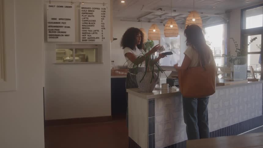 The woman pays for her coffee in the restaurant