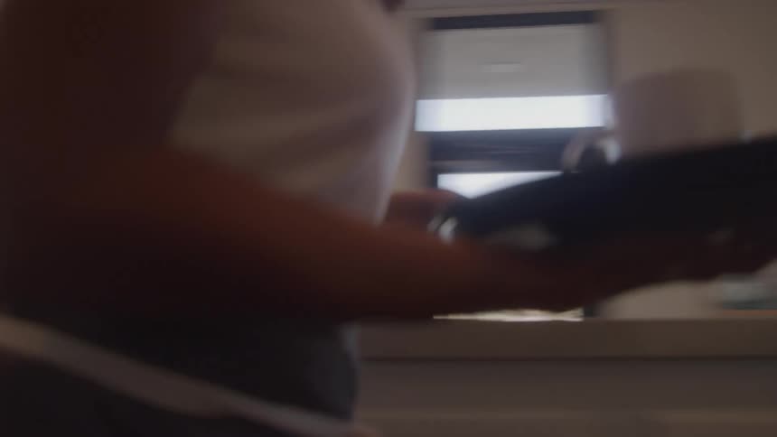 The woman clears the tray off the counter in the restaurant