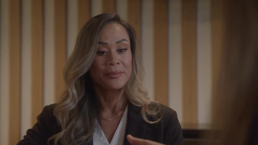 A closeup of a womans face as she listens intently and speaks to a person who is out of frame