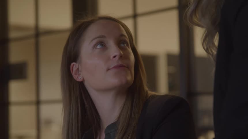 The woman looks up to talk with a coworker