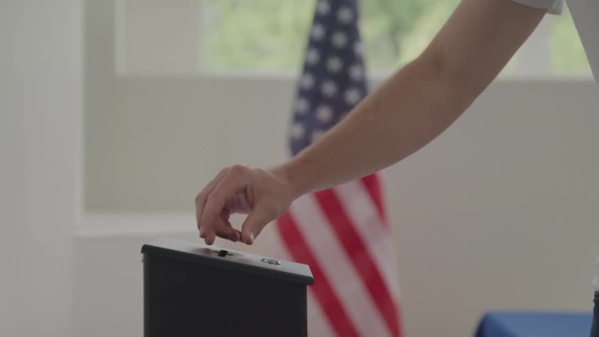 A man casts his vote in the box