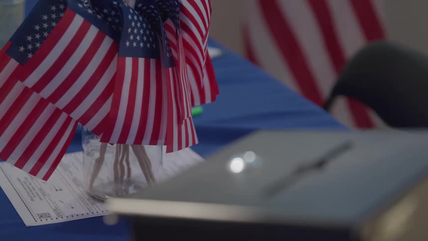 Small us flags arranged on a polling station table