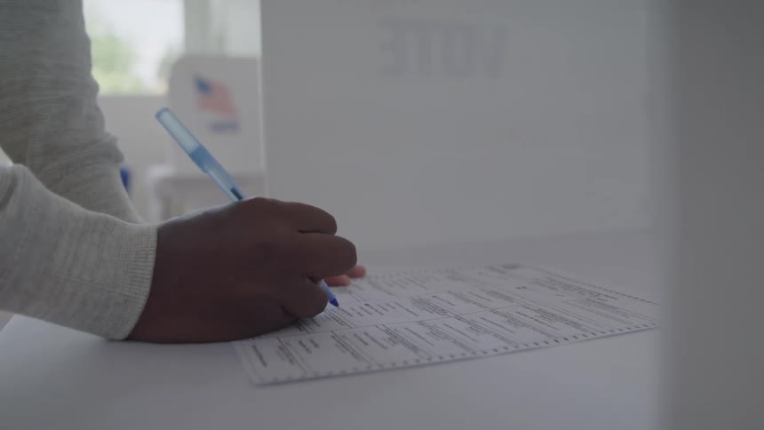 The person fills out the form with a pen