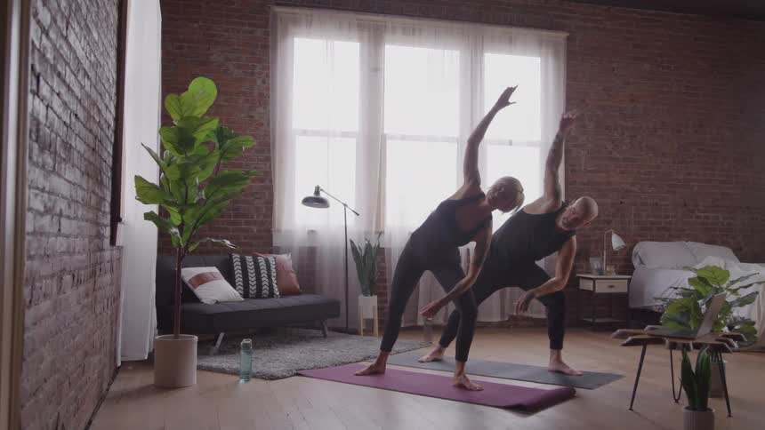A man and woman do yoga together