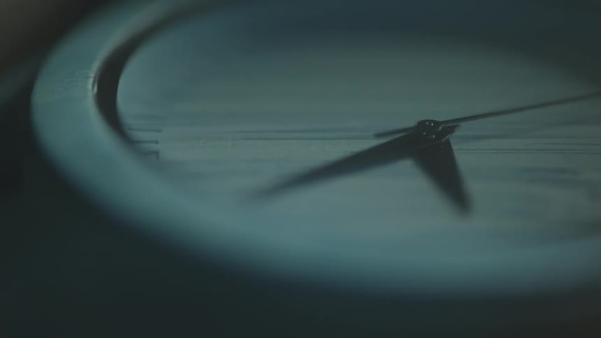Hands of an analog clock in a blurred closeup