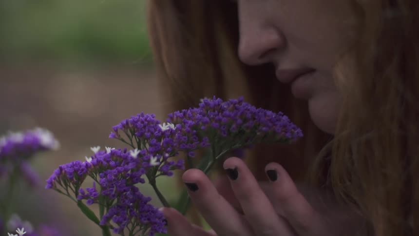 Woman smelling purple flowers