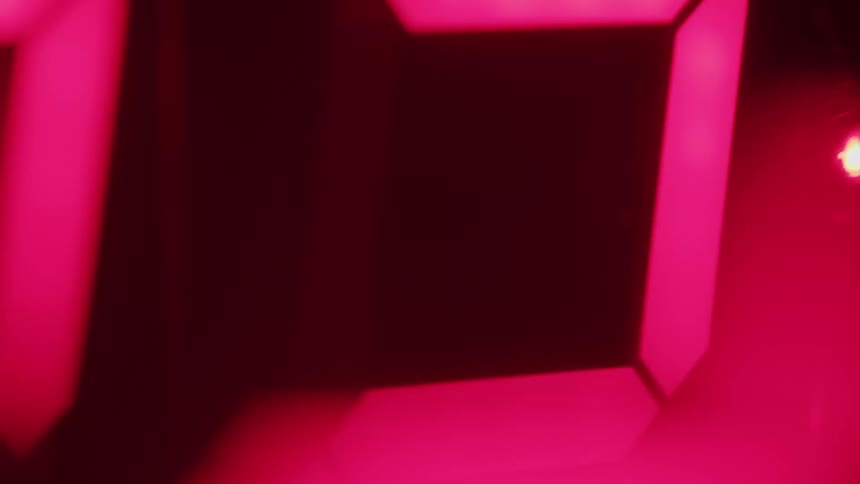 Red numbers of a digital clock in blurred closeup