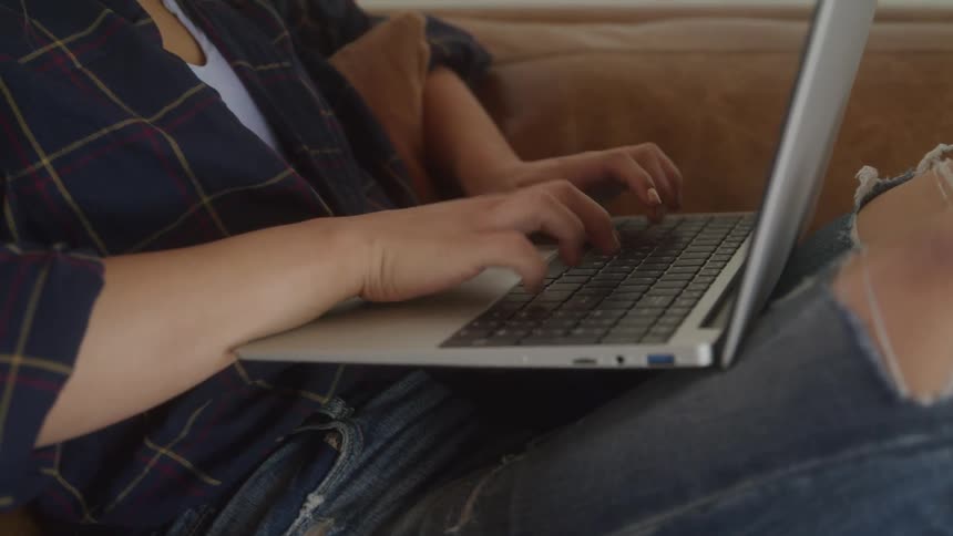 The woman is typing on her laptop