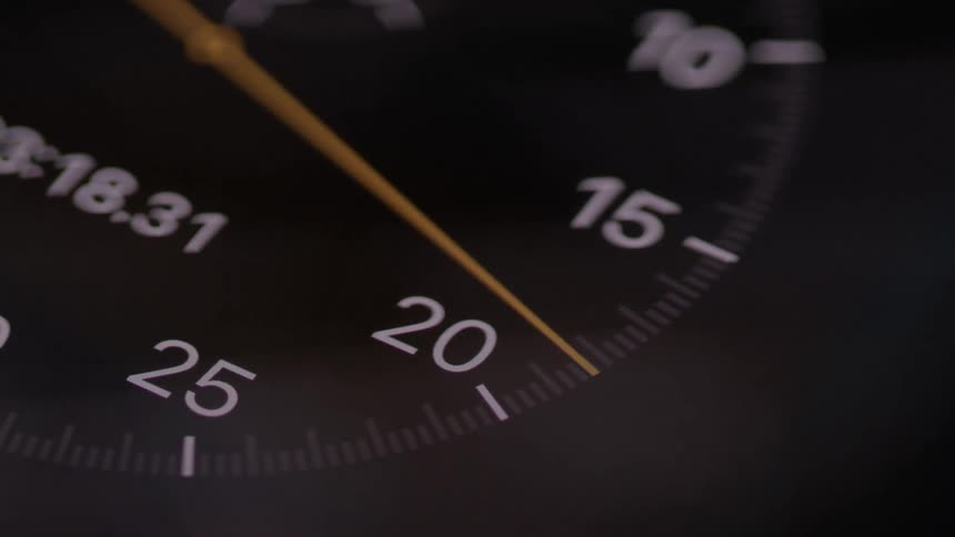 Black watch dial in closeup with yellow hand