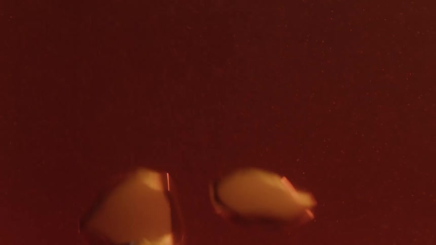 A macro shot captures goldencolored bubbles rising and floating up through a dark ambercolored liquid