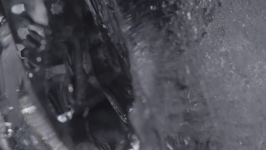 A small piece of ice with fissures in it slowly rotates to its left