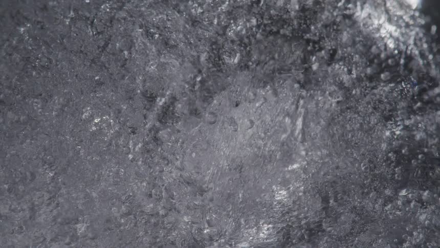Trapped air bubbles can be seen beneath the surface of a piece of ice