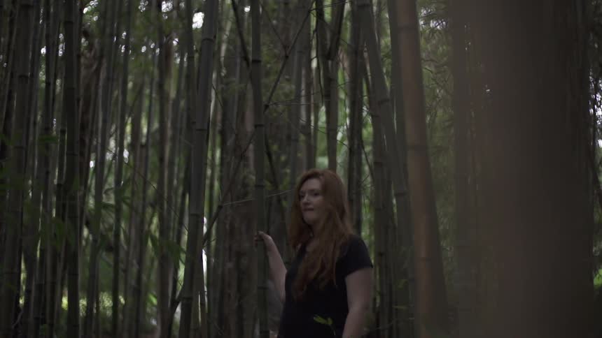 Woman holding a tree in a dense forest