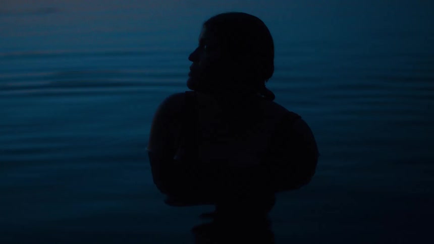 A woman in a pool of water at night