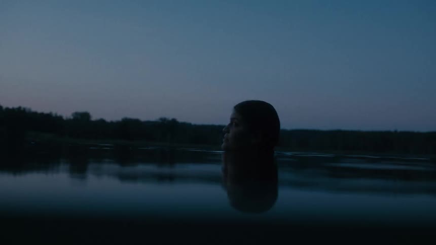 A person looks nervous as they wade in a lake and look around