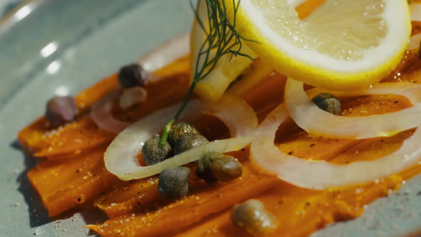 Gourmet carrot lox with vegetables plated on a ceramic dish