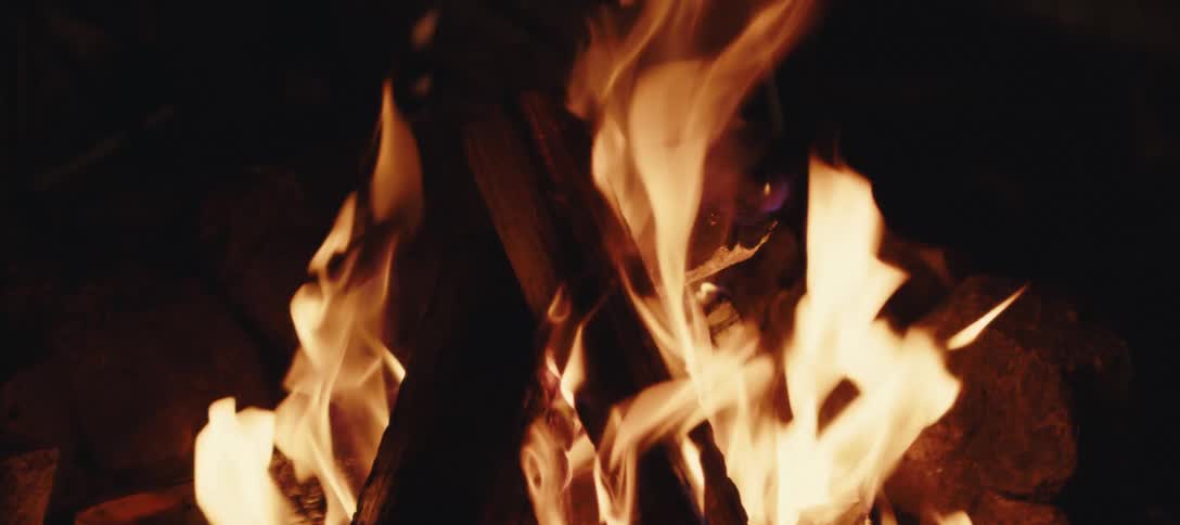 Closeup of a campfire with burning logs and flames rising
