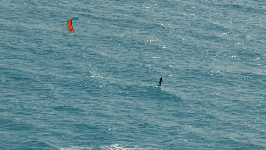 The person is kite surfing on the open ocean