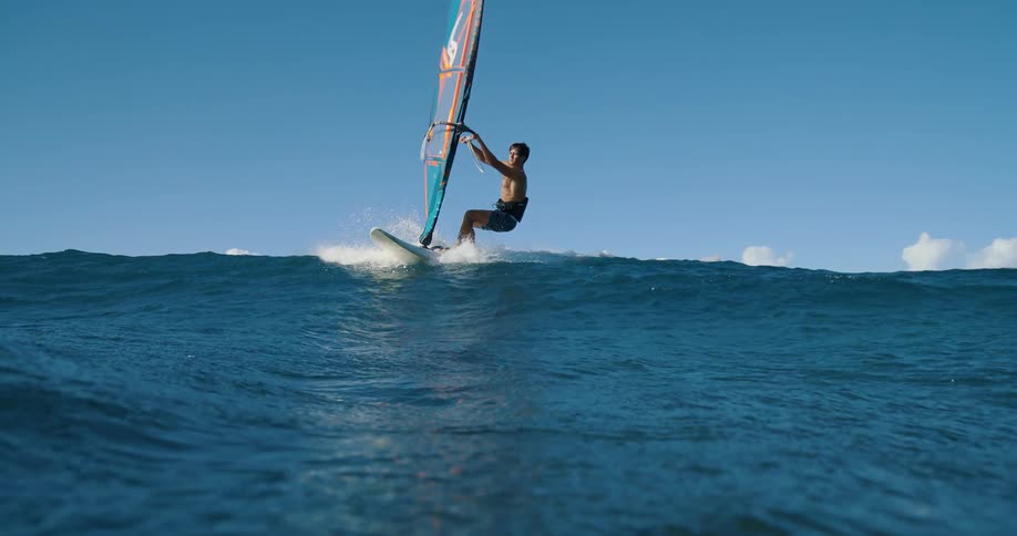 The man rides towards the shore while windsurfing